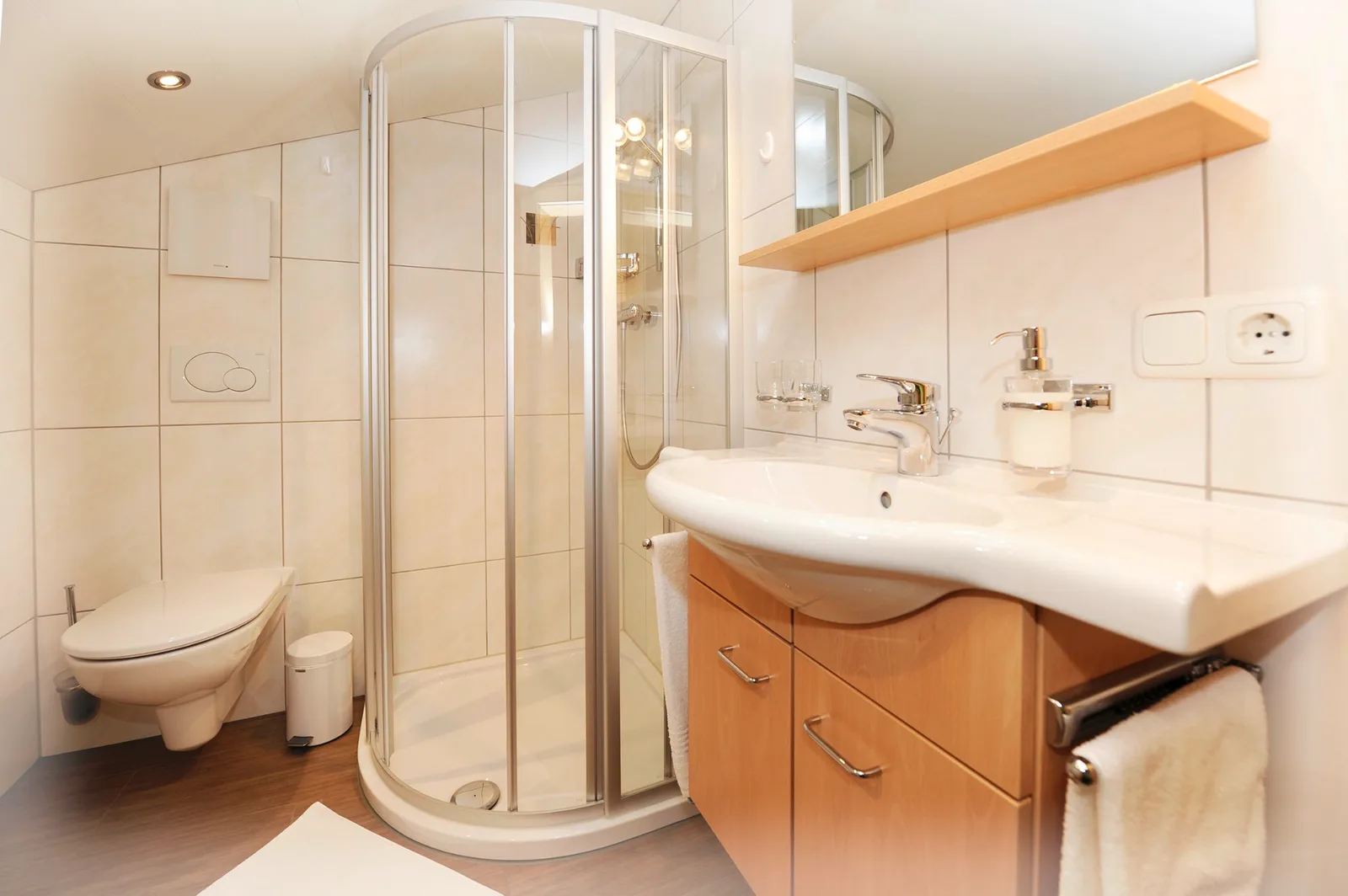 Badezimmer mit Eck-Duschkabine, WC und Waschtisch